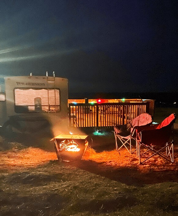 Nighttime fire pit glowing in front of seasonal RV lots.