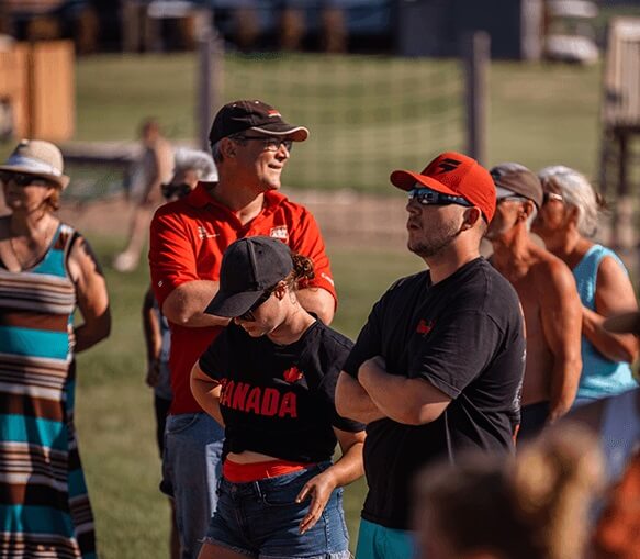 A crowd of people standing outdoors on a sunny day.