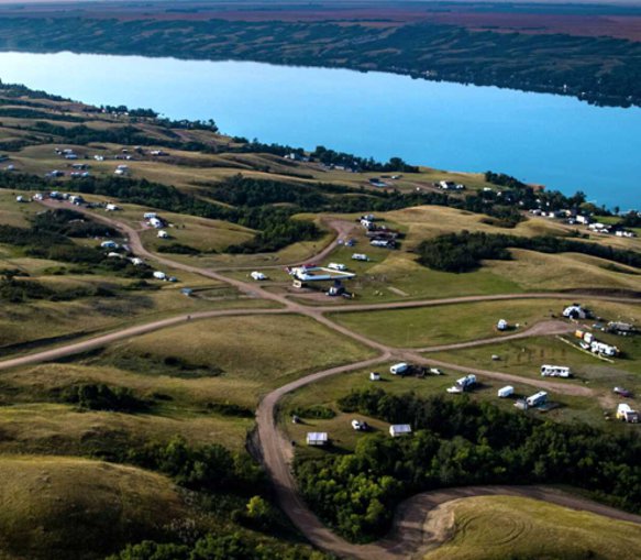 Aerial view of a lakeside campground with various parked trailers.